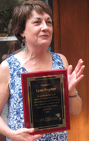 Lynn Stephen holds a plaque that commemorates her service to CLLAS.